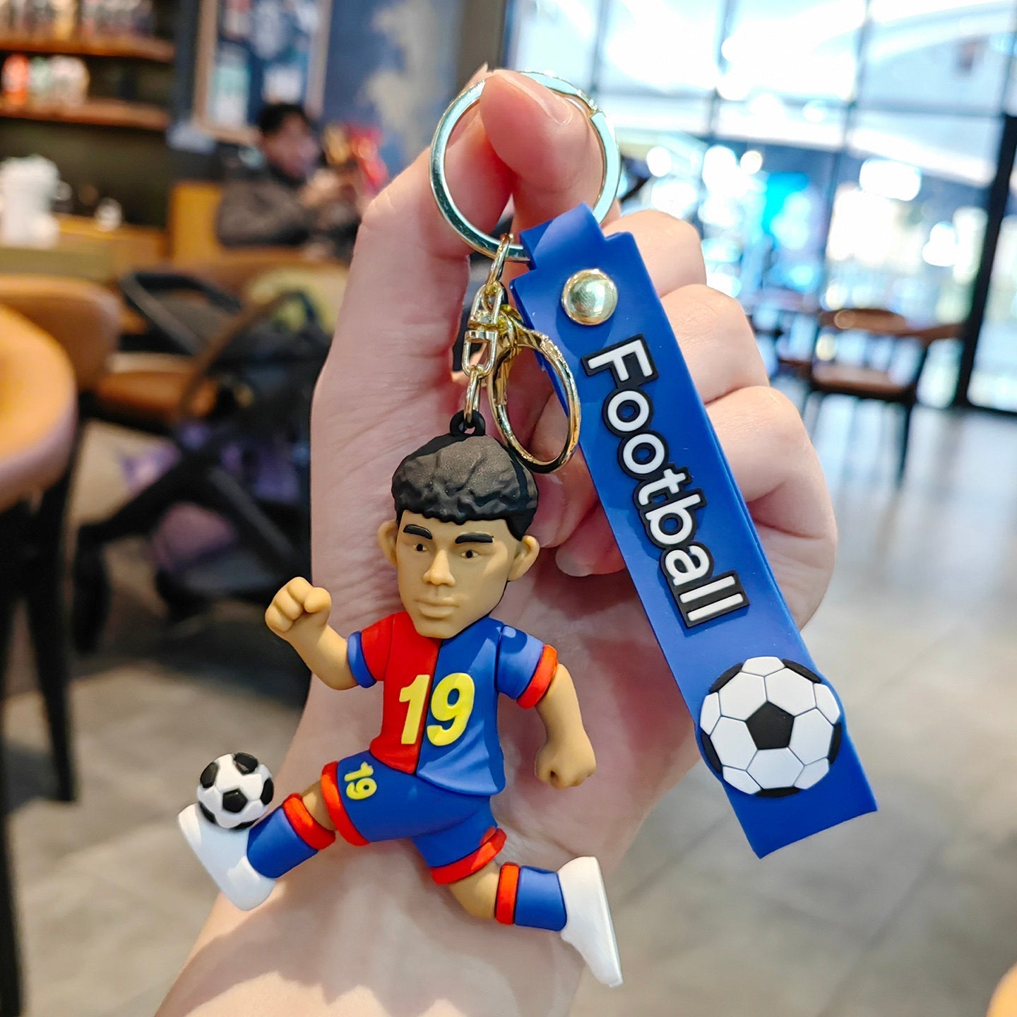 Football keychain with a design featuring professional football players