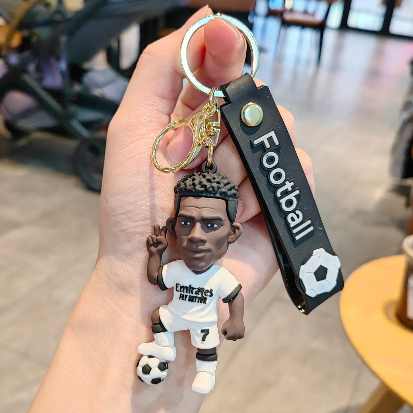 Football keychain with a design featuring professional football players