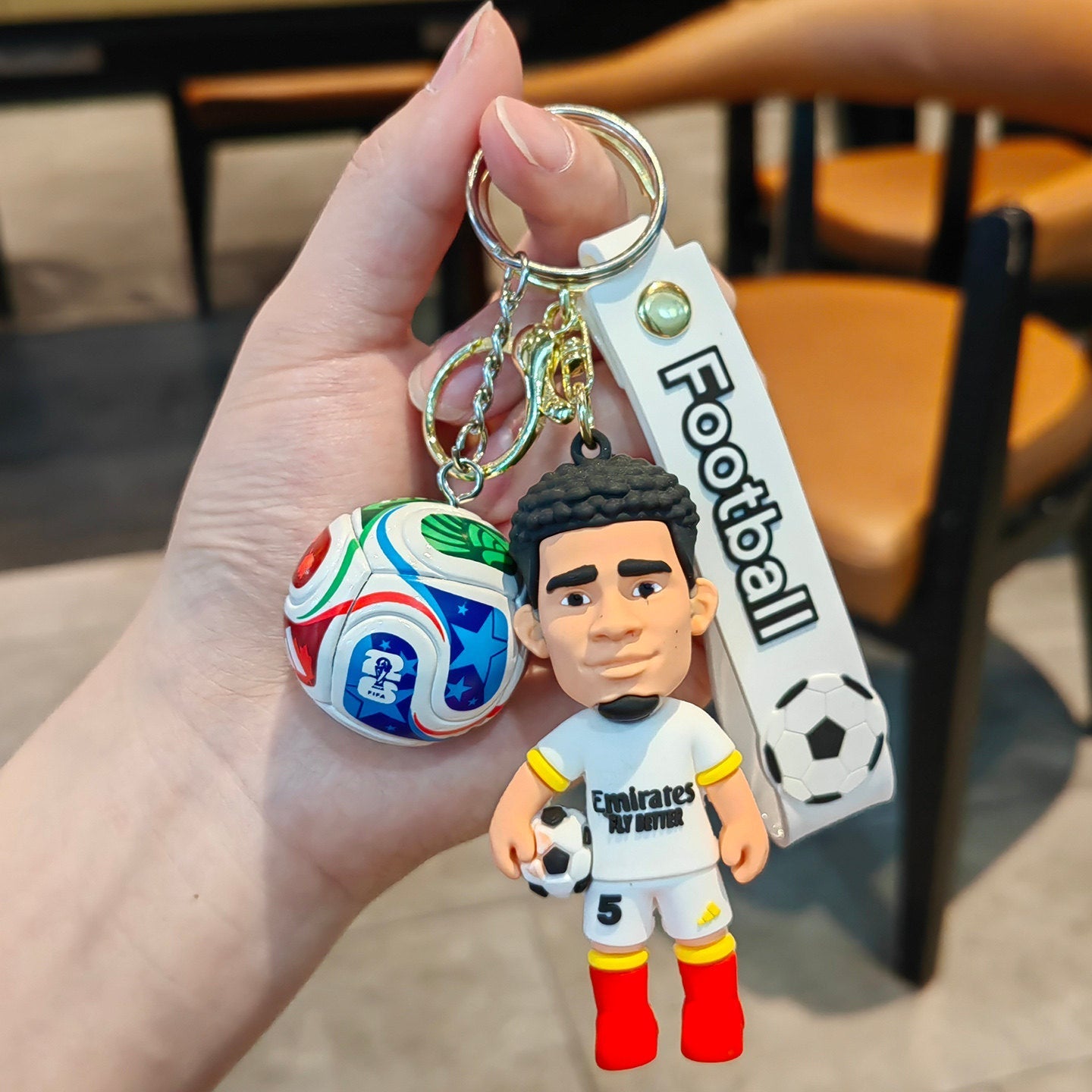 Football keychain with a design featuring professional football players