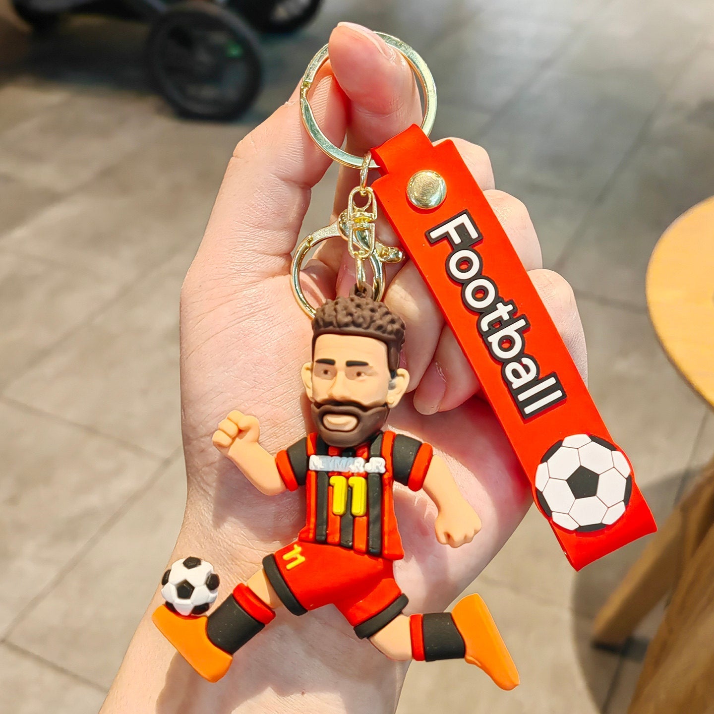 Football keychain with a design featuring professional football players