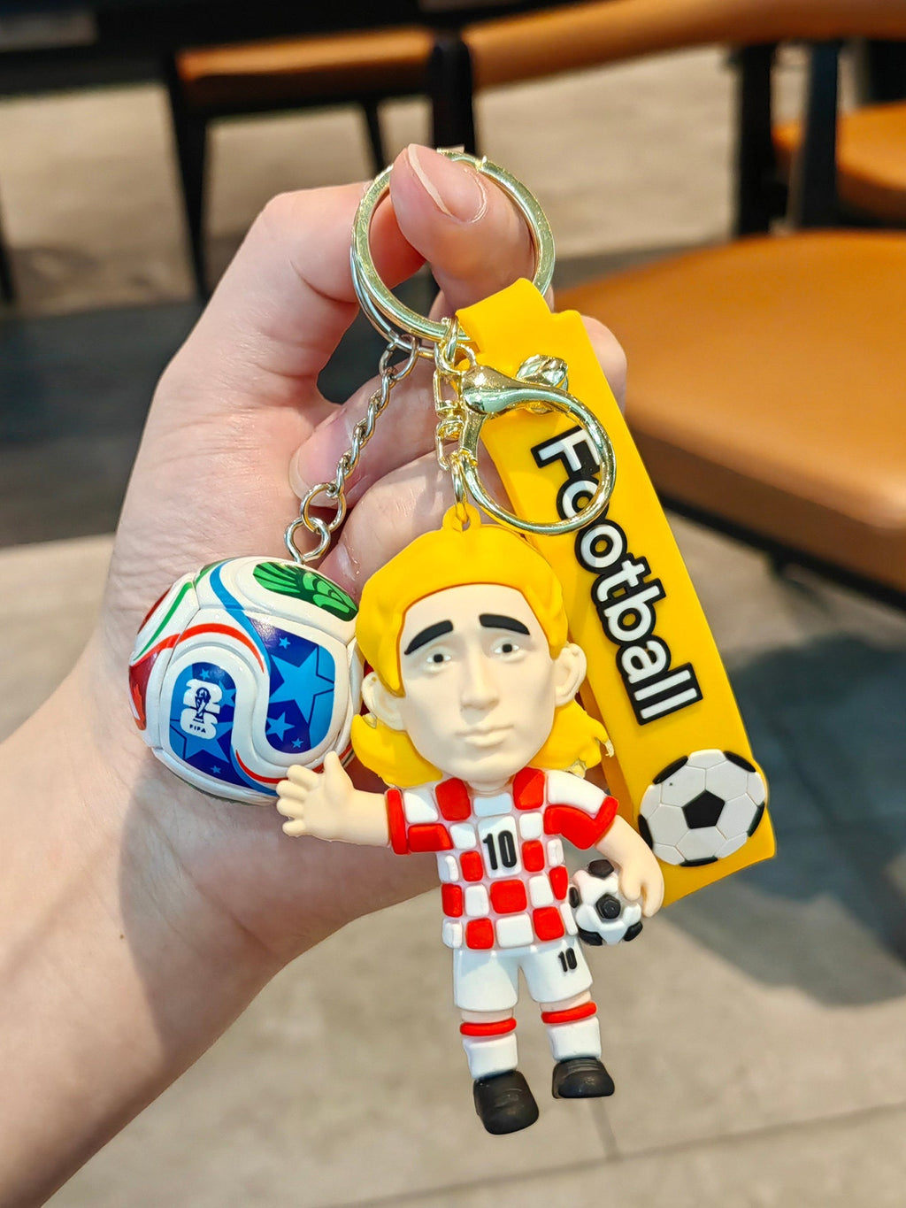 Football keychain with a design featuring professional football players
