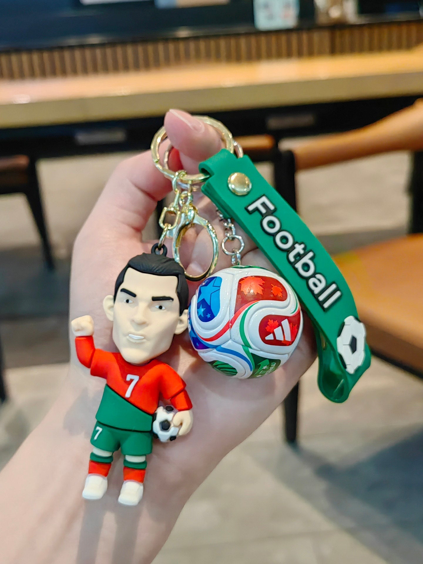 Football keychain with a design featuring professional football players