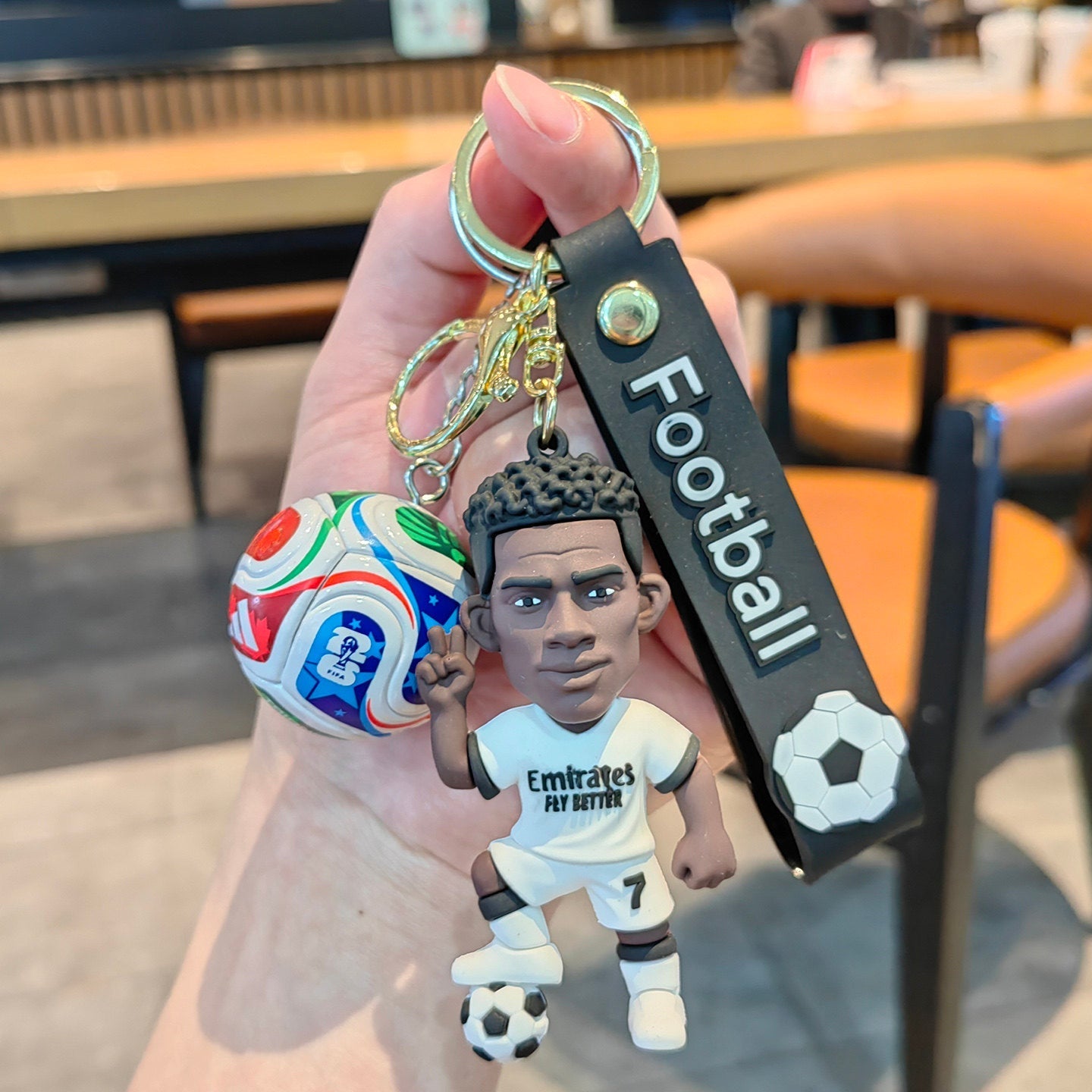 Football keychain with a design featuring professional football players