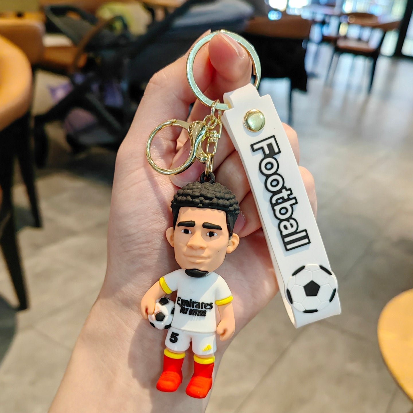 Football keychain with a design featuring professional football players