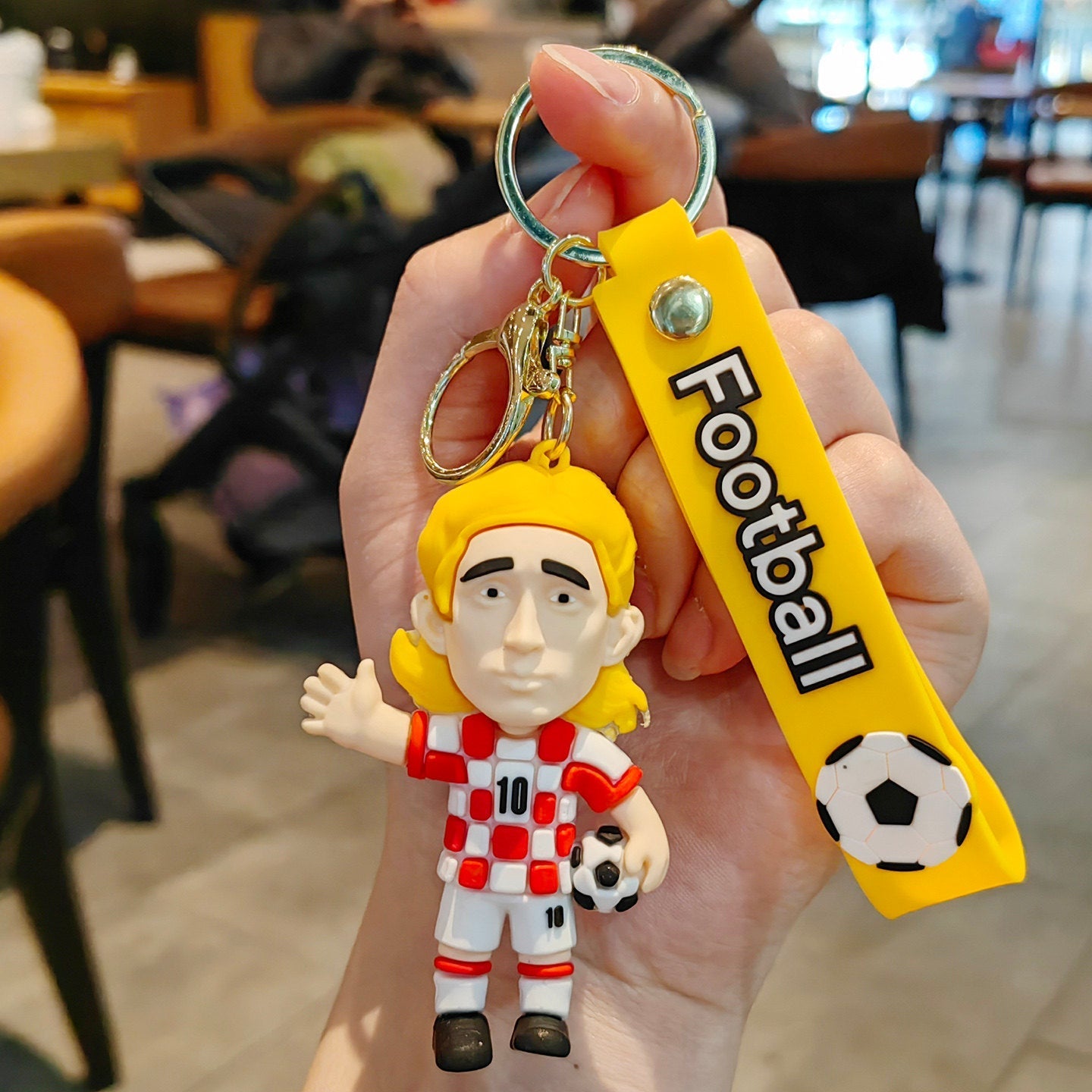Football keychain with a design featuring professional football players