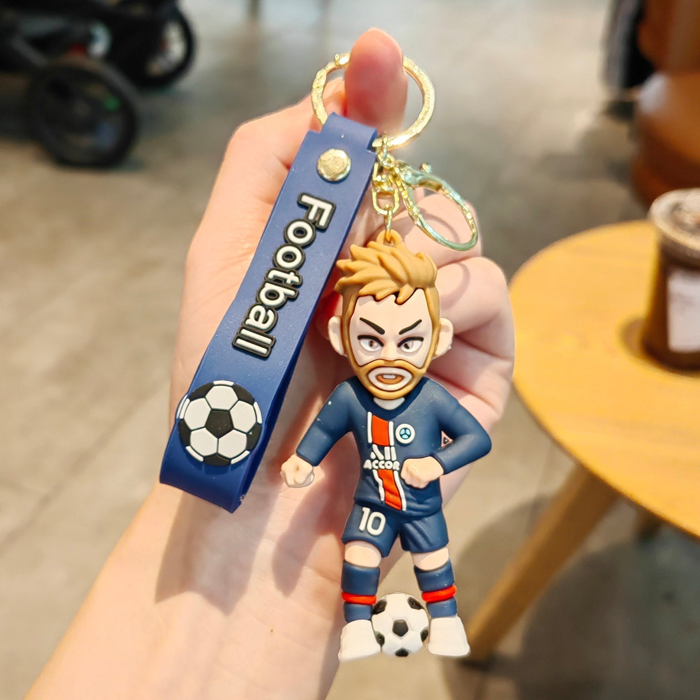 Football keychain with a design featuring professional football players