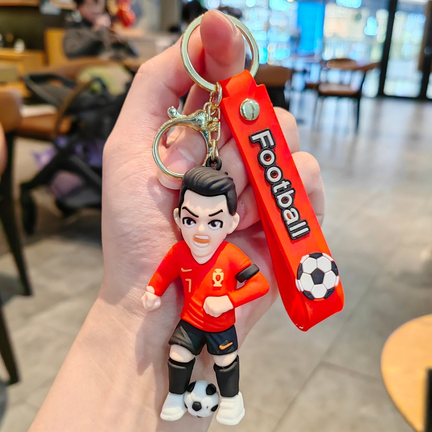 Football keychain with a design featuring professional football players
